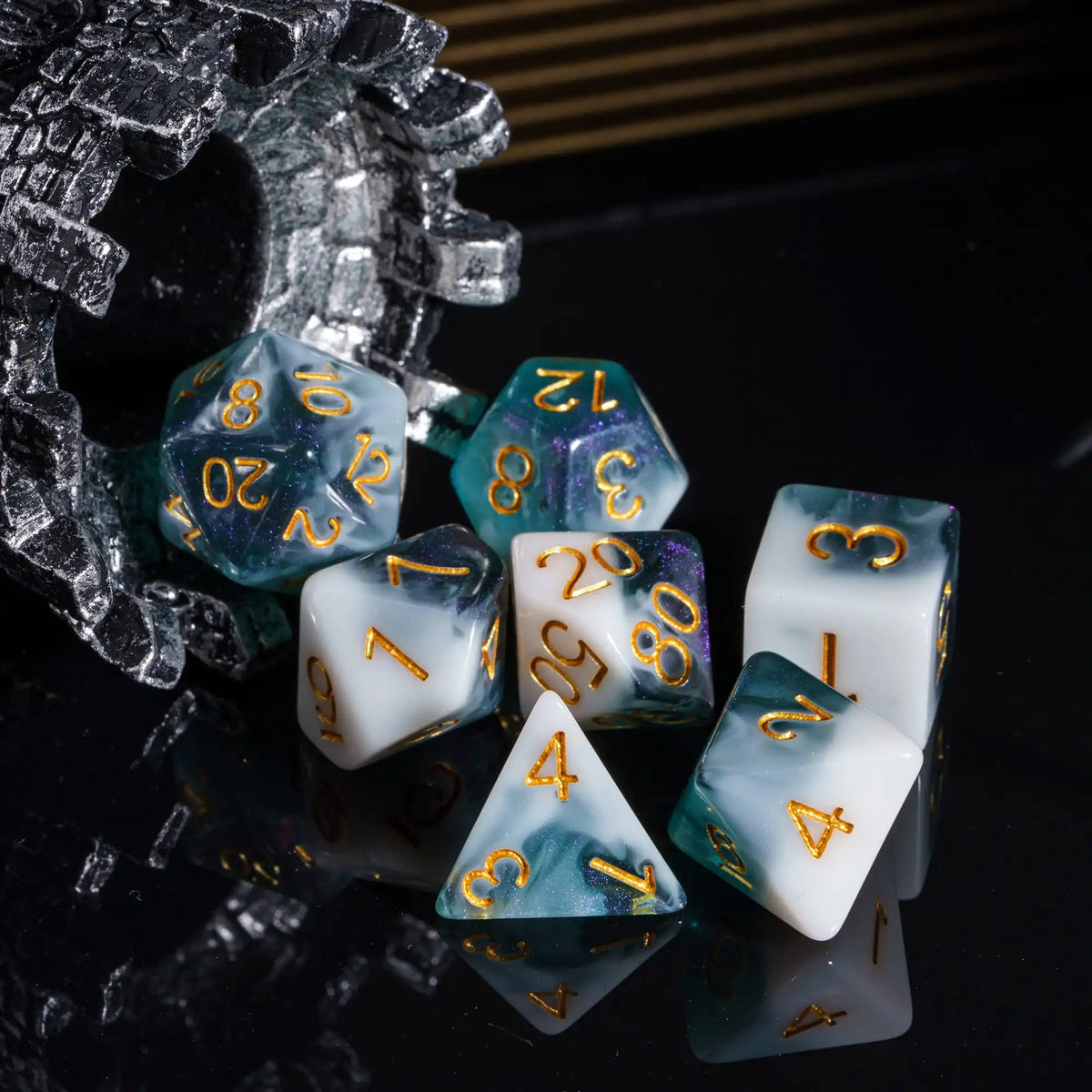A set of premium glitter resin polyhedral dice including a d10, d8, and d6 resting on a reflective black surface.