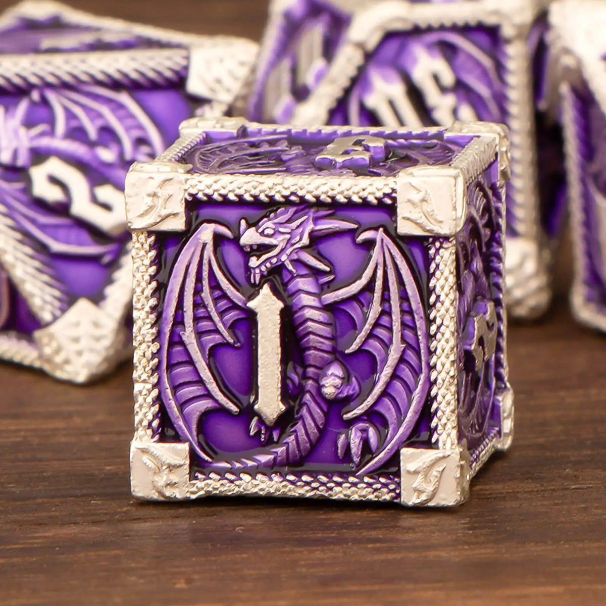 A purple metal die with a dragon design and silver trim, part of a premium dice set.
