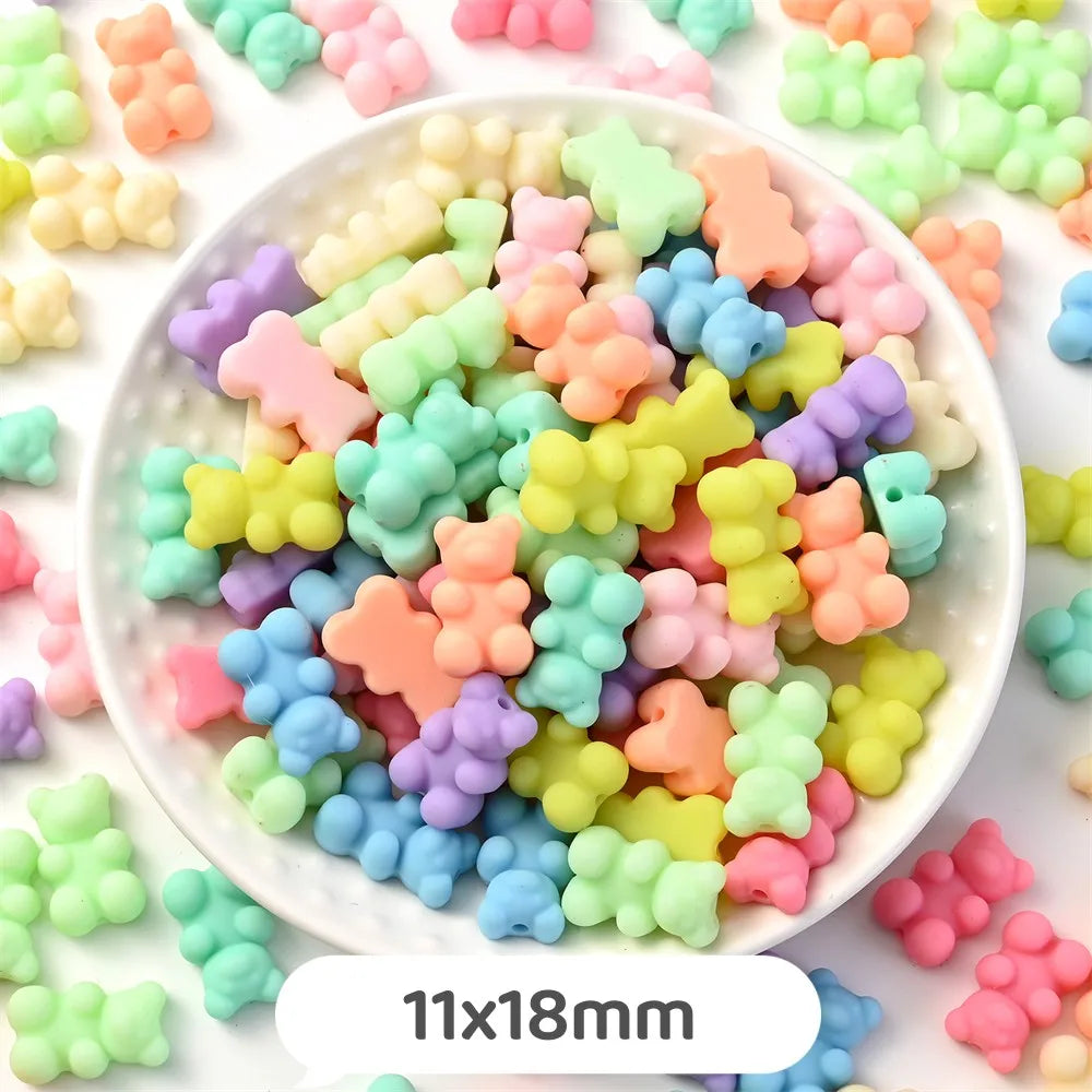A bowl filled with pastel bear-shaped acrylic craft beads in various colors and sizes.