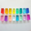 A collection of colorful, translucent acrylic building blocks in various shades of rainbow colors arranged in a row.