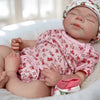 A lifelike 18-inch silicone reborn baby doll named Pascale is sleeping peacefully in a white blanket.