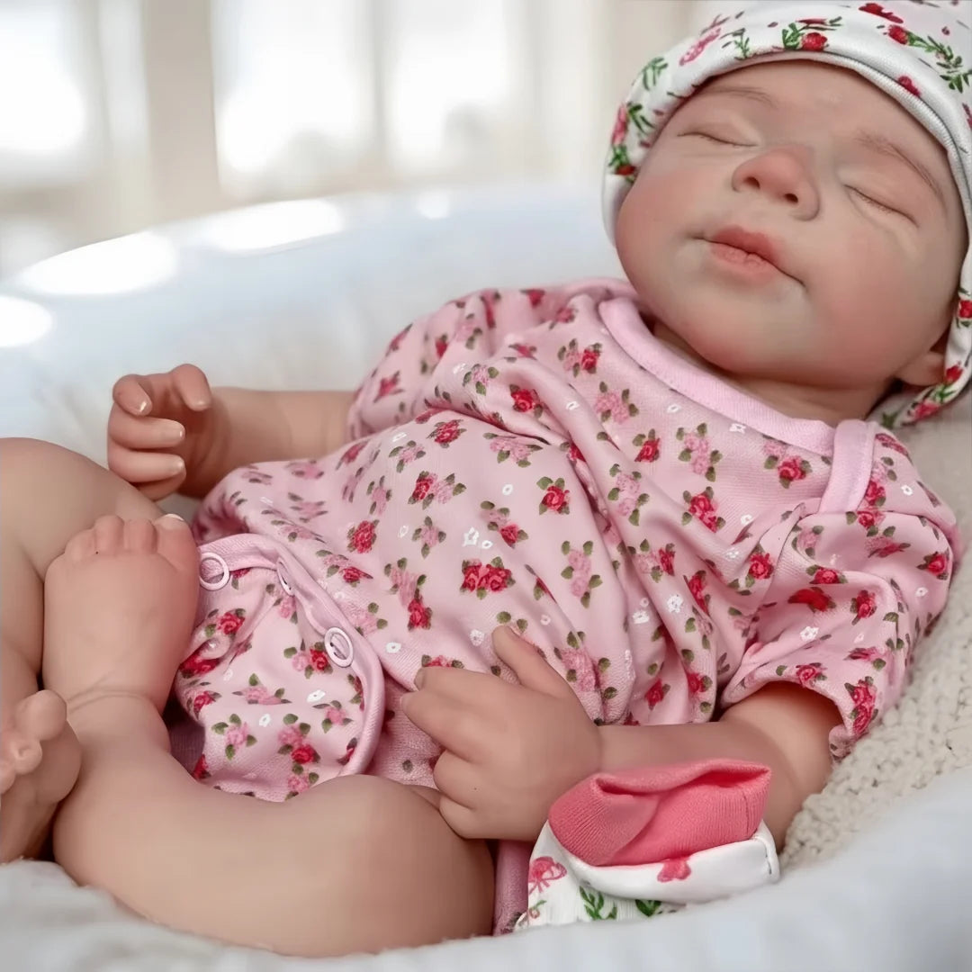 A lifelike 18-inch silicone reborn baby doll named Pascale is sleeping peacefully in a white blanket.