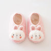 Pair of pink and white plush baby slippers shaped like rabbits with anti-slip soles