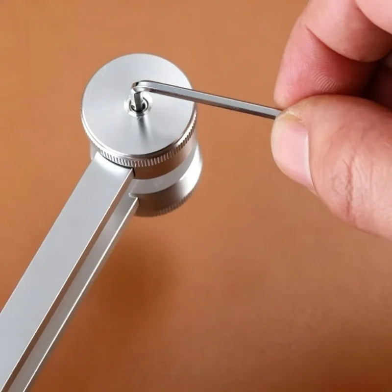 A hand is holding a silver tuning fork, which is attached to a metal holder for sound healing.
