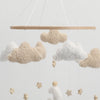 Handmade felt baby mobile featuring clouds and stars suspended by thin strings.