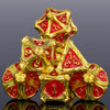 A stack of seven gold metal dice featuring red and gold markings, reflecting on a dark surface.
