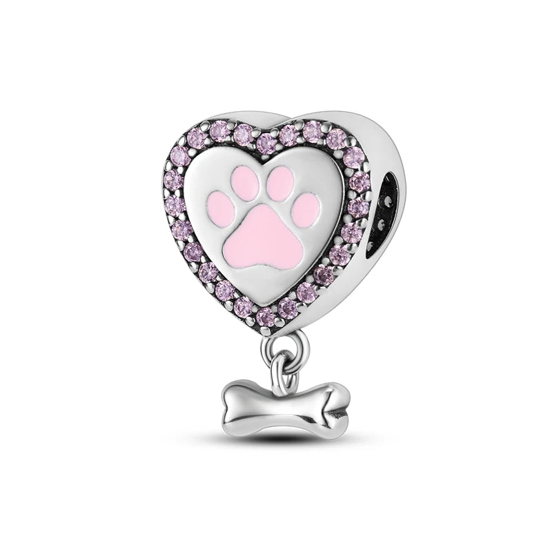 A heart-shaped sterling silver charm bead featuring a pink paw print design surrounded by small pink zircon stones.