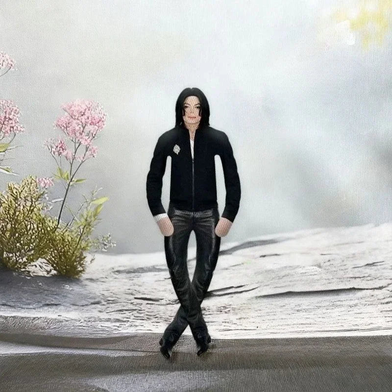 A black plush doll resembling Michael Jackson with a hood and dark clothing standing in a snowy outdoor setting.