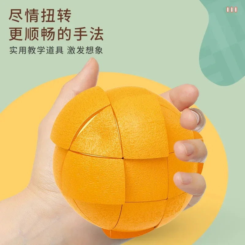 A hand holds an orange fruit-shaped 3x3 puzzle cube for kids.