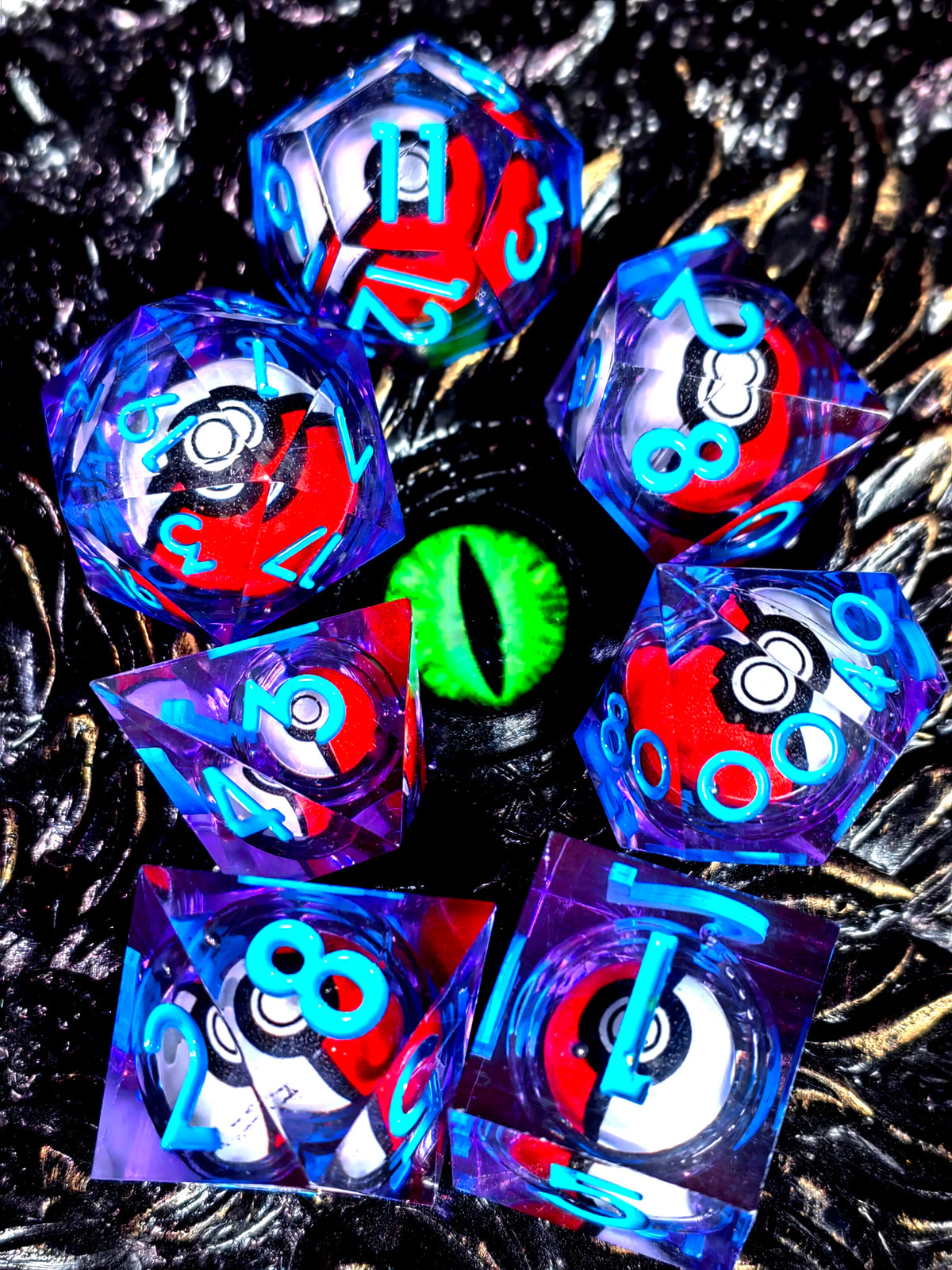 A collection of iridescent resin dice with spinning dragon eye cores scattered on a dark surface.