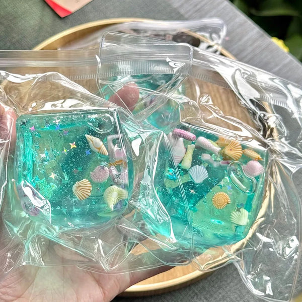 Clear blue ocean sensory stress balls filled with sea shells and glitter in plastic packaging