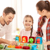 A girl and a man interact with a green pop-up animal toy set for cause and effect learning.