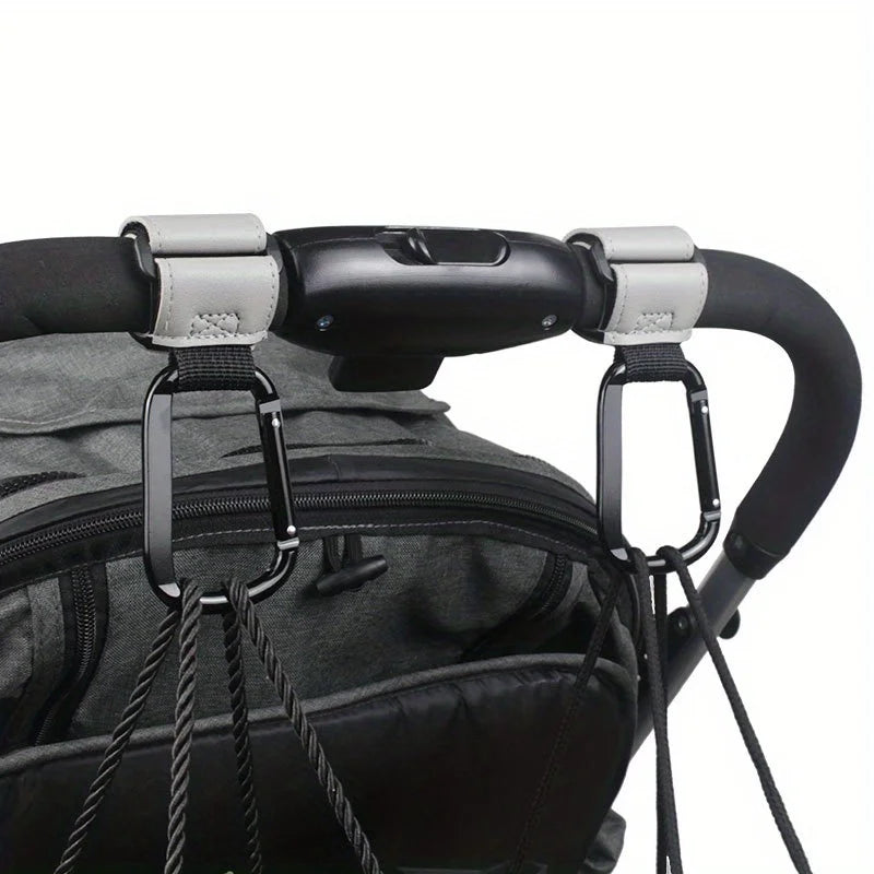 Close-up of heavy-duty stroller hooks attached to a black fabric bag or carrier.