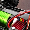 Close-up of an independent ESC with a red and black housing, showing metal heat dissipation and a power switch on a 1:14 scal