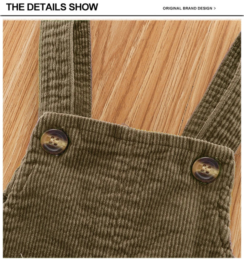 Close-up of olive green baby cotton overalls showing the textured fabric and wooden buttons on the chest pocket.