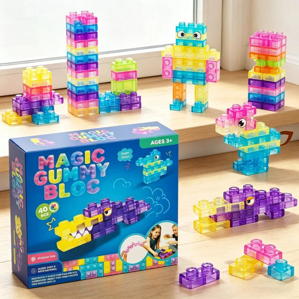 Une boîte de blocs gomme Magiques de construction de différentes couleurs et formes, exposés sur une surface en bois.