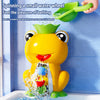 A yellow frog bath toy is spinning a small water wheel in a bathtub, demonstrating the pleasure of bathing.