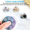 A hand spinning a colorful metal fidget spinner on a white marble surface.