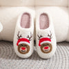 Pair of white plush indoor slippers decorated with reindeer faces and red noses