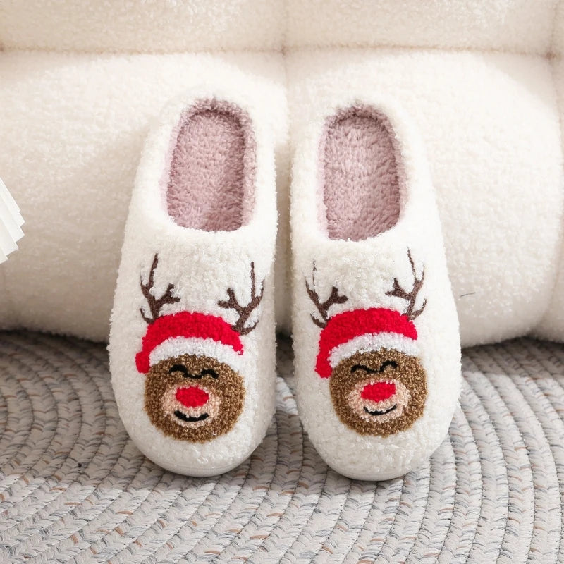 Pair of white plush indoor slippers decorated with reindeer faces and red noses
