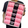A box containing five skeins of pink alpaca wool yarn for knitting and crochet.