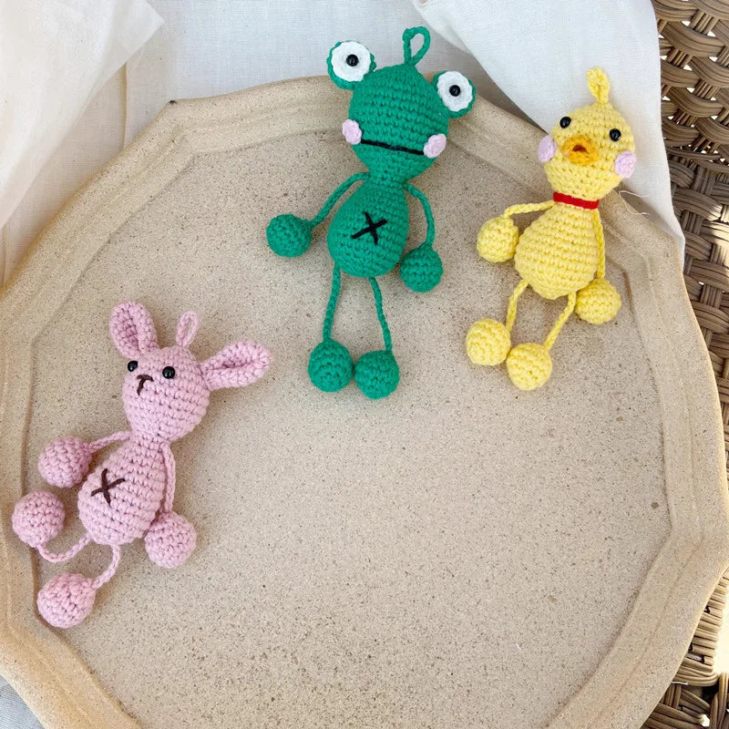 Handmade crochet frog hanging ornament in green and yellow colors displayed on a light background.