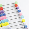 A series of colorful rhinestone pen blanks arranged in a diagonal line, showing various shades of pink, purple, blue, and yel