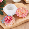 Pink and peach silicone candle molds with lit candles displayed on a wooden board