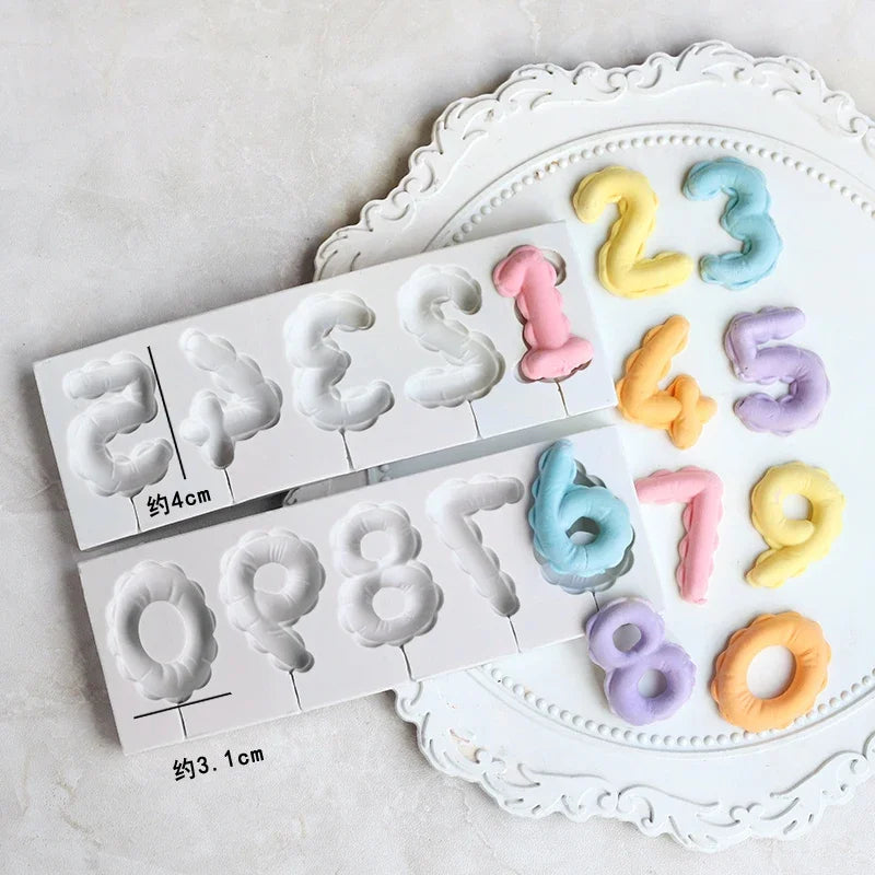 A silicone mold set featuring numbers 1 through 9 in pastel colors arranged on a white decorative plate.