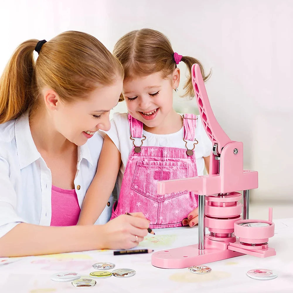 Two girls are using a pink multi-size button making machine kit to create buttons.