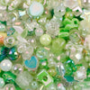 A close-up of clear and green iridescent acrylic beads used for DIY jewelry making.