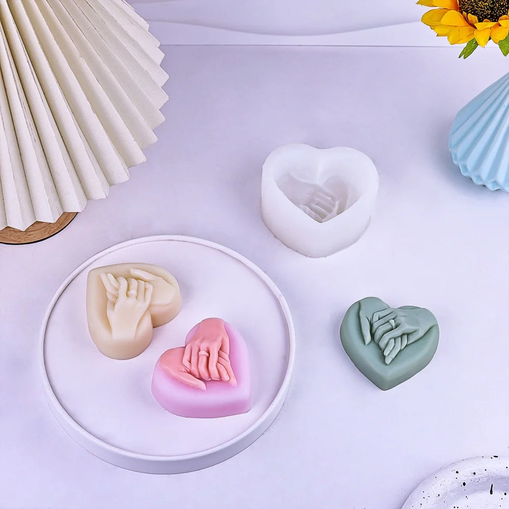 A collection of heart-shaped silicone molds in various pastel colors, including white, pink, and green, displayed on a white 