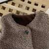 A close-up of a brown, fluffy lamb wool vest with a dark brown lining and a silver button.