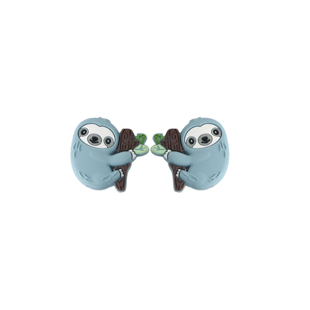 A pair of light blue silicone beads shaped like sloths holding green leaves for DIY crafts.