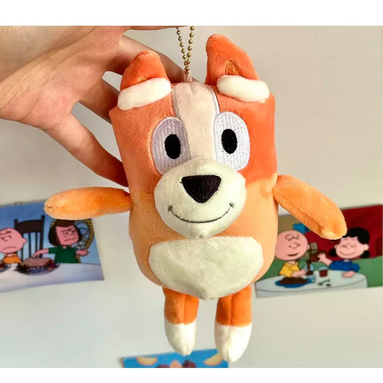 An orange and white plush toy resembling a dog, held by a hand against a background of children's show illustrations.