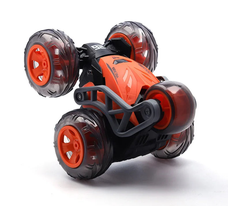 Orange and black stunt car with five rubber wheels shown from the side.