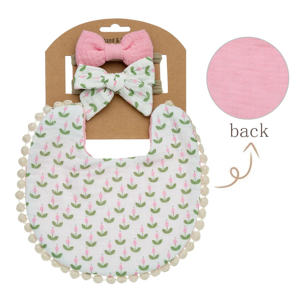 A pink and white baby flower bib and headband set with a bow