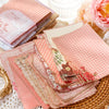 A stack of vintage pink and floral paper sheets for journaling and scrapbooking