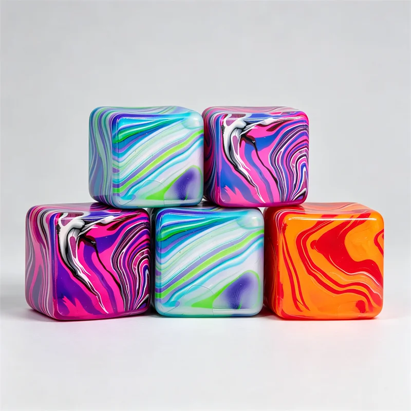 Three colorful, marbled cube toys in shades of blue, purple, pink, and orange.