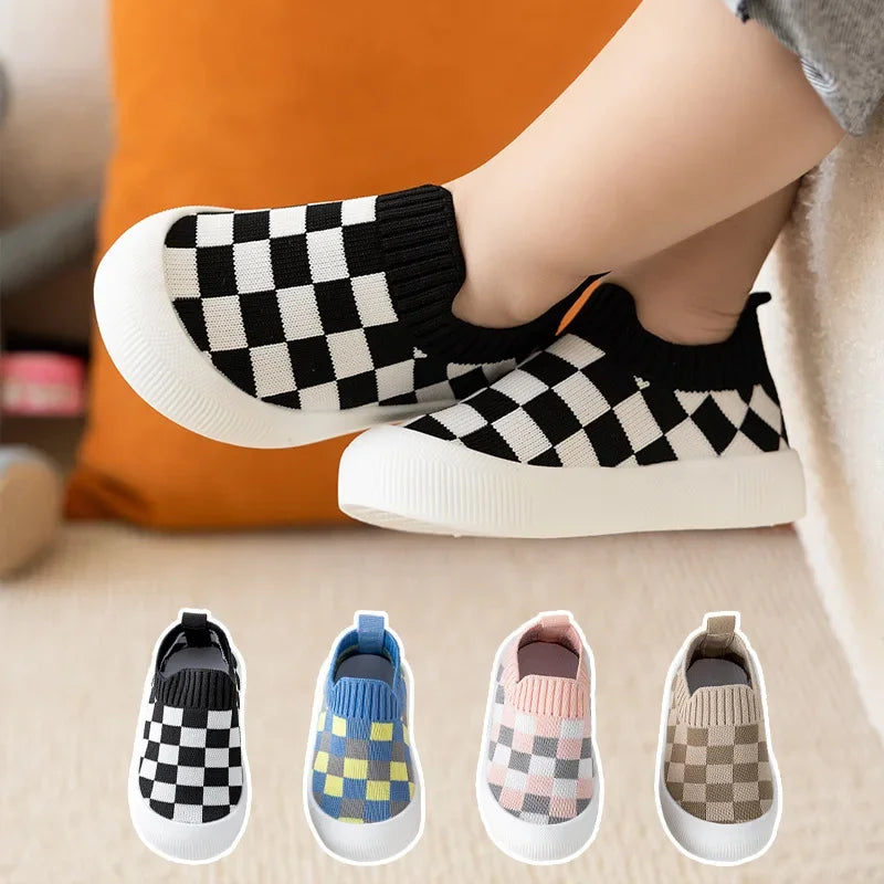 A collection of classic plaid slip-on toddler shoes for first walkers in various colors and patterns.