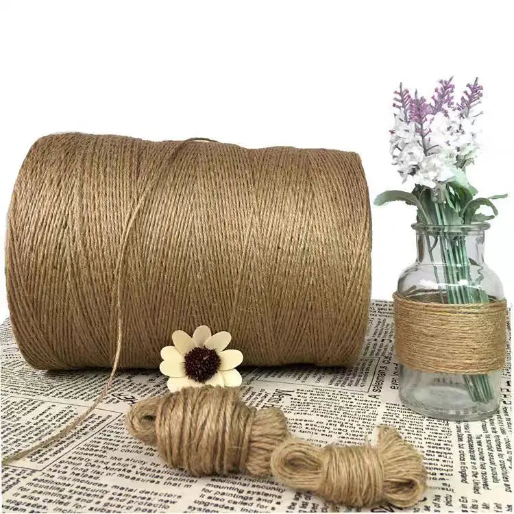 A spool of natural jute twine is shown next to a small bundle and a glass jar.
