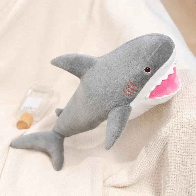 A gray and pink plush stuffed animal depicting a killer whale and a great white shark.