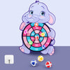 A purple cartoon elephant holding a circular dart board with colored sticky balls on a purple background.