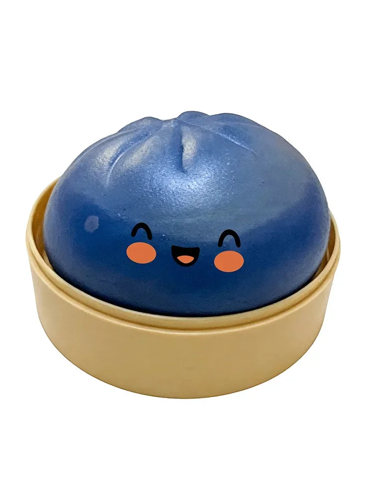 A blue, round squishy toy shaped like a dumpling is resting in a light beige dish.