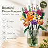 A bouquet of artificial flowers in various colors and textures displayed in a glass vase.