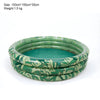 A stack of green inflatable kids' play pool rings featuring a tropical leaf pattern.