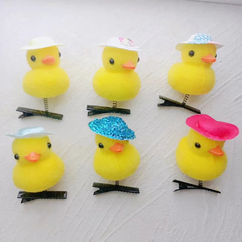 Five yellow duck plush toys with various colored hats attached to their heads