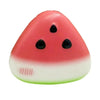 A pink watermelon-shaped stress relief toy with black seeds and a white base.