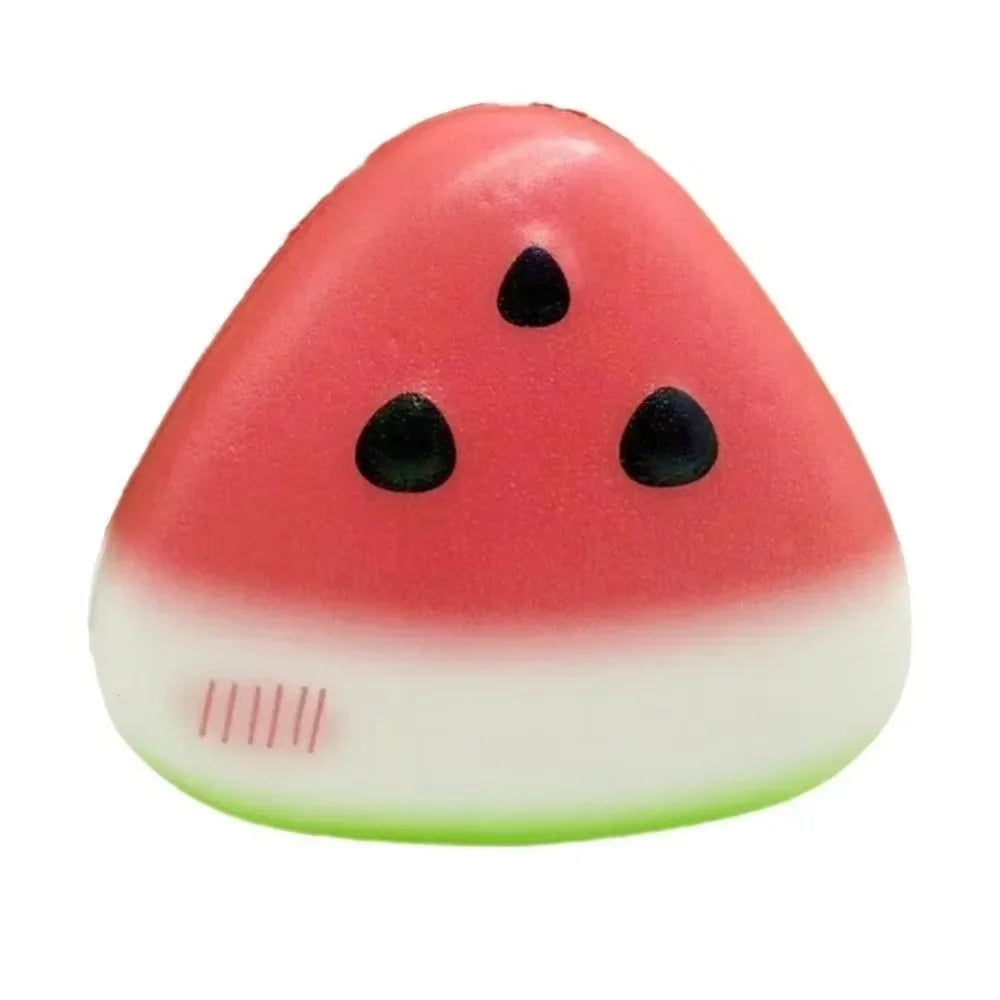 A pink watermelon-shaped stress relief toy with black seeds and a white base.