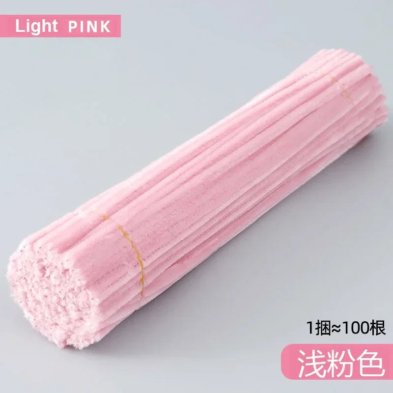 A tube of light pink craft material, likely chenille stems, shown in a close-up view.